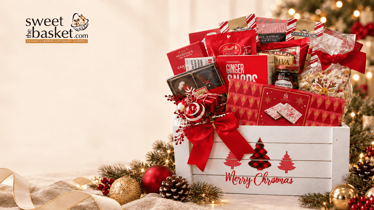 A Christmas-themed gourmet gift basket from Sweet of the Basket, featuring an assortment of chocolates, ginger snaps, and treats arranged in a white wooden crate decorated with red bows and 'Merry Christmas' script, surrounded by festive pinecones, ornaments, and a blurred Christmas tree background.